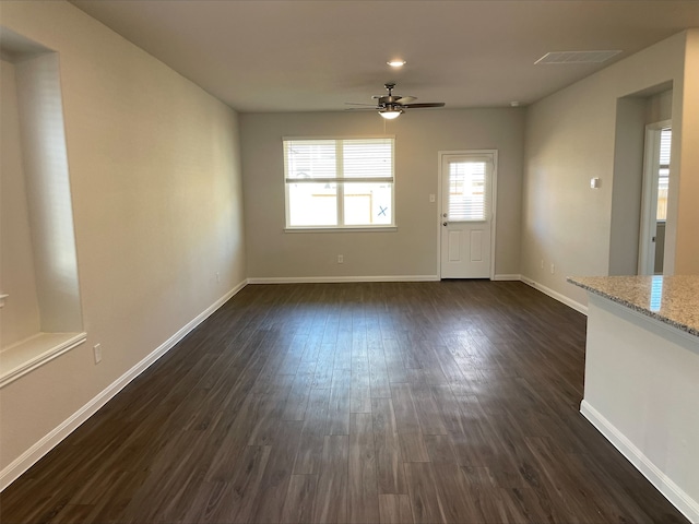 unfurnished living room with dark hardwood / wood-style flooring and ceiling fan