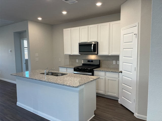 kitchen featuring stainless steel appliances, white cabinetry, sink, and an island with sink