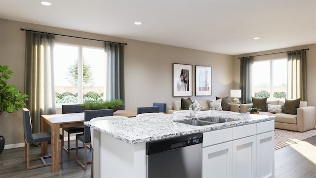 kitchen with sink, dishwasher, light stone counters, white cabinets, and a center island with sink