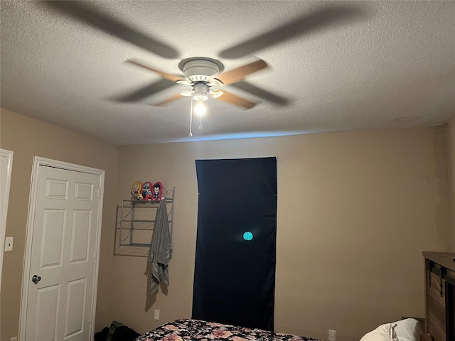 bedroom featuring ceiling fan and a textured ceiling