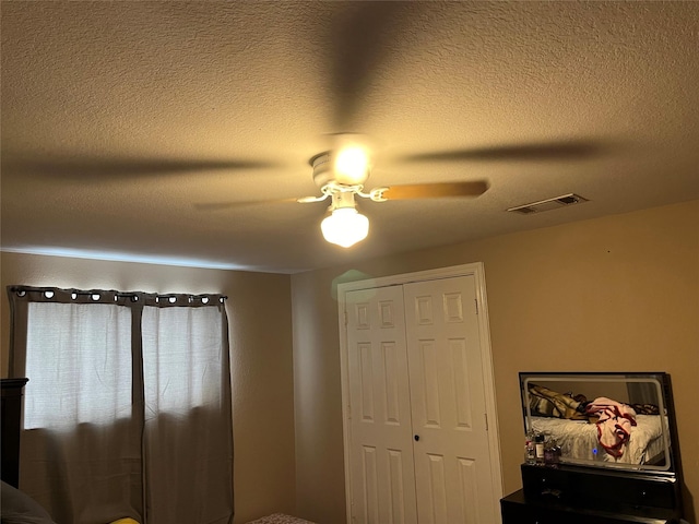bedroom with a textured ceiling, a closet, and ceiling fan