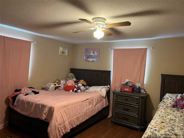 bedroom featuring ceiling fan, dark hardwood / wood-style floors, and a textured ceiling