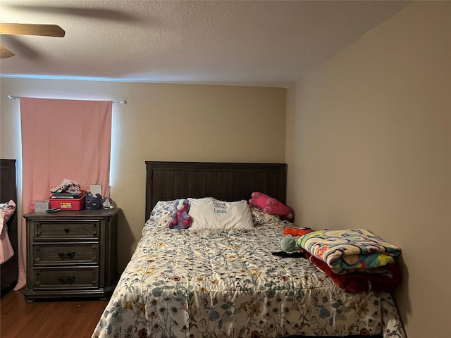 bedroom featuring a textured ceiling, dark hardwood / wood-style floors, and ceiling fan