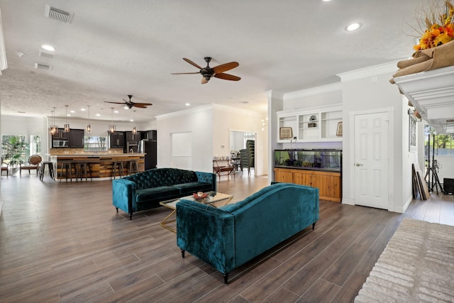 living room with ornamental molding, dark hardwood / wood-style floors, and a textured ceiling