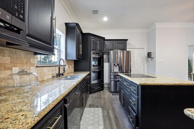 kitchen featuring sink, dark hardwood / wood-style floors, a center island, light stone counters, and black appliances