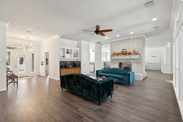 living room featuring a brick fireplace, a wealth of natural light, dark hardwood / wood-style floors, and a textured ceiling