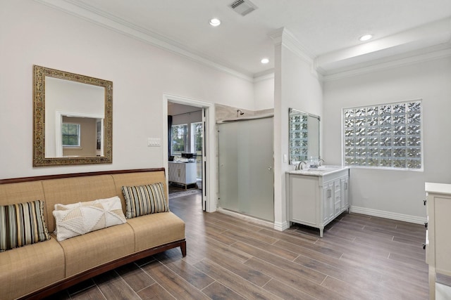 bathroom featuring hardwood / wood-style flooring, crown molding, vanity, and walk in shower