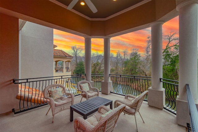 balcony at dusk featuring a ceiling fan