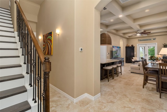 interior space with baseboards, coffered ceiling, arched walkways, french doors, and beamed ceiling