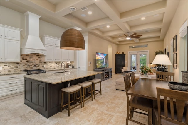 kitchen with backsplash, french doors, custom exhaust hood, coffered ceiling, and a sink