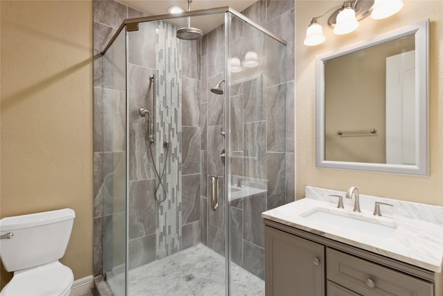 full bathroom with vanity, a shower stall, and toilet