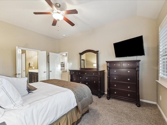 carpeted bedroom featuring ceiling fan, lofted ceiling, and ensuite bath