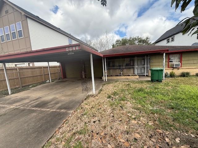 view of side of property featuring cooling unit, a carport, and a lawn