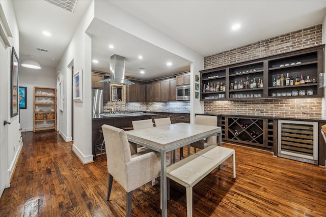 dining area with wine cooler, brick wall, dark hardwood / wood-style flooring, and bar area