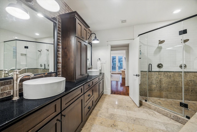 bathroom with a shower with door, vanity, and french doors