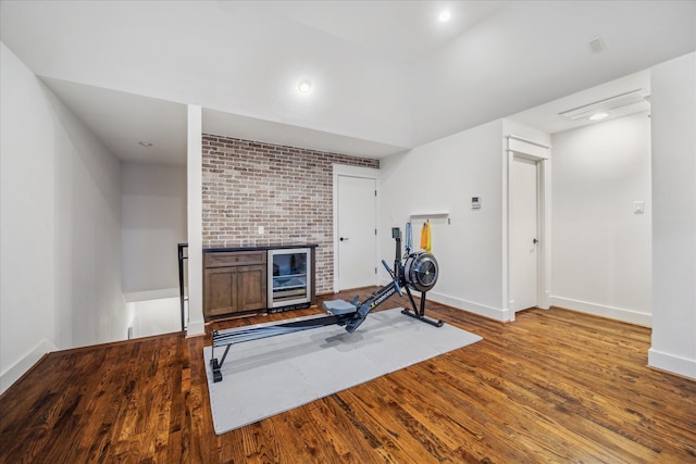 exercise area with beverage cooler and light hardwood / wood-style floors