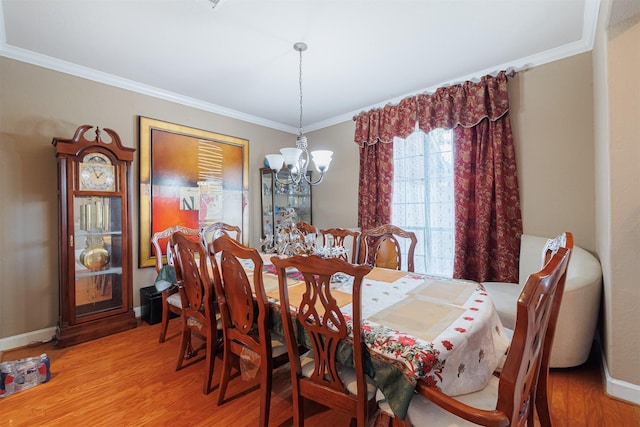 dining area with ornamental molding, hardwood / wood-style floors, and an inviting chandelier