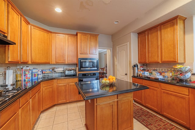 kitchen featuring backsplash, a kitchen island, stainless steel microwave, wall oven, and light tile patterned flooring