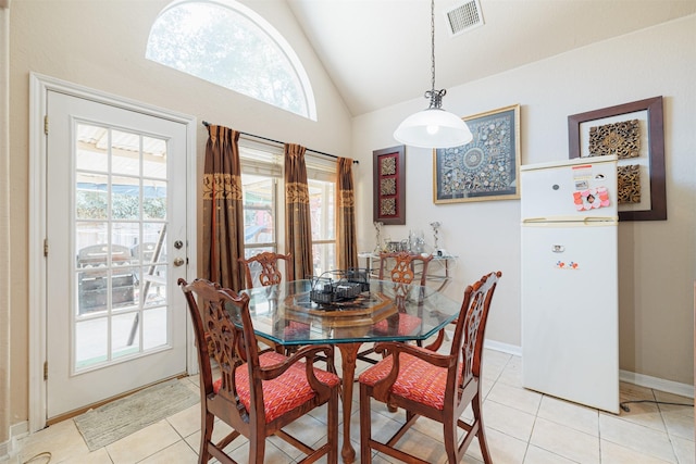 dining space featuring high vaulted ceiling and light tile patterned floors