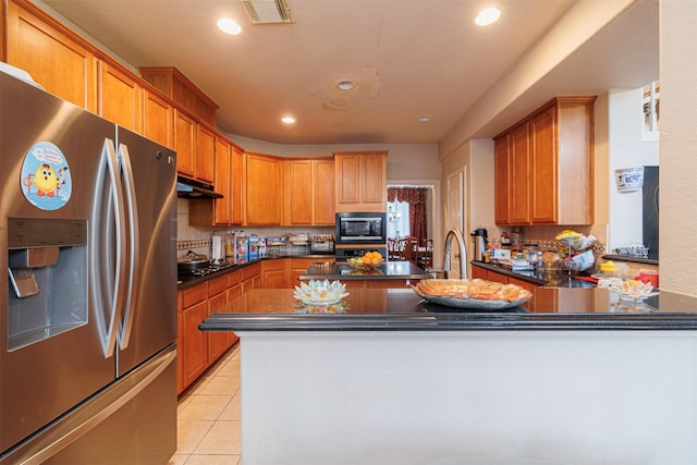 kitchen featuring light tile patterned floors, sink, black appliances, and kitchen peninsula