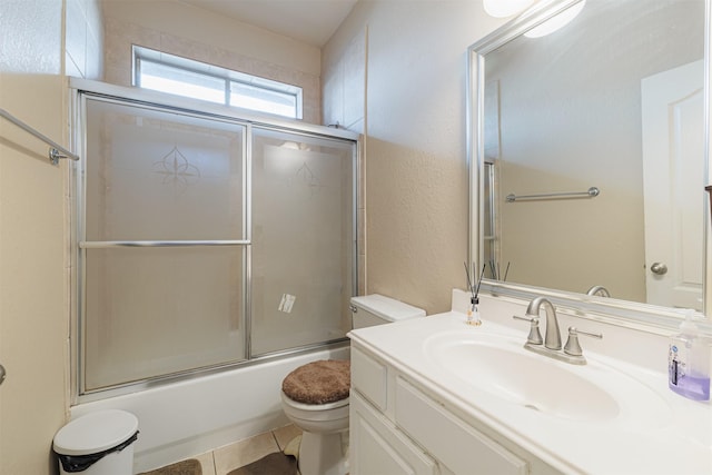 full bathroom with tile patterned flooring, vanity, shower / bath combination with glass door, and toilet