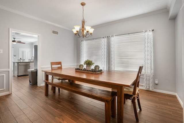 dining room featuring crown molding, ceiling fan with notable chandelier, and dark hardwood / wood-style flooring