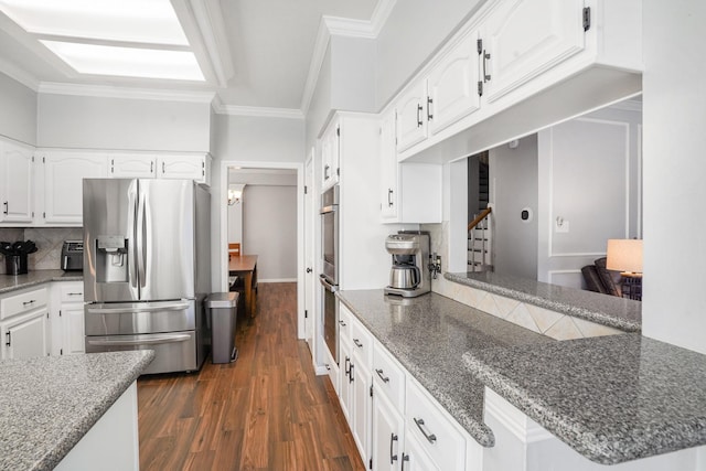 kitchen featuring white cabinetry, kitchen peninsula, stainless steel appliances, crown molding, and dark wood-type flooring