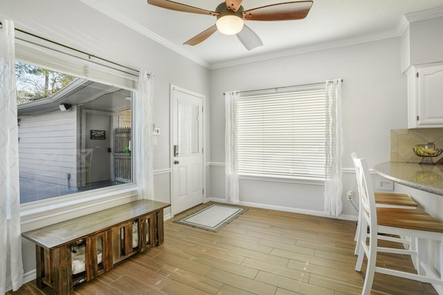 entryway featuring ceiling fan, ornamental molding, and light hardwood / wood-style floors