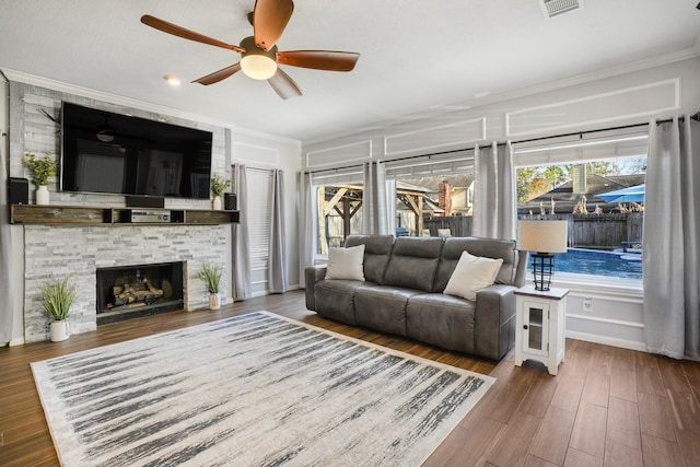 living room with crown molding, a healthy amount of sunlight, and dark wood-type flooring