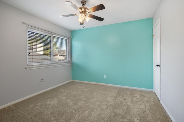 unfurnished room with ceiling fan and carpet