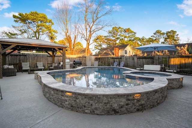 view of swimming pool featuring a grill, exterior kitchen, an in ground hot tub, a gazebo, and a patio area