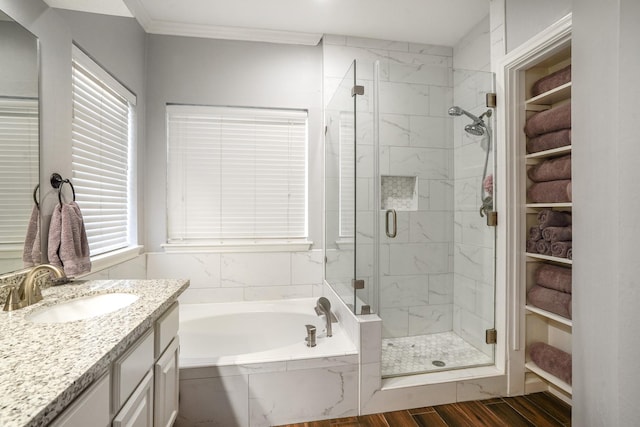 bathroom featuring vanity, hardwood / wood-style floors, ornamental molding, and separate shower and tub