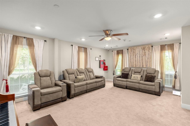 living room featuring ceiling fan, light colored carpet, and plenty of natural light