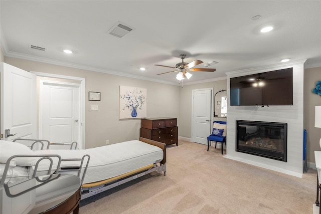 carpeted bedroom featuring crown molding, a large fireplace, and ceiling fan