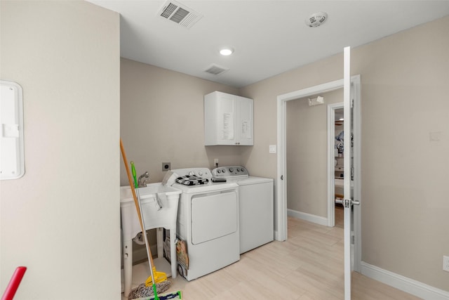 laundry area with cabinets and washing machine and clothes dryer