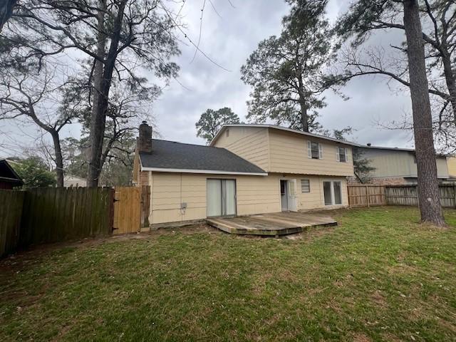 back of property featuring a yard and a deck