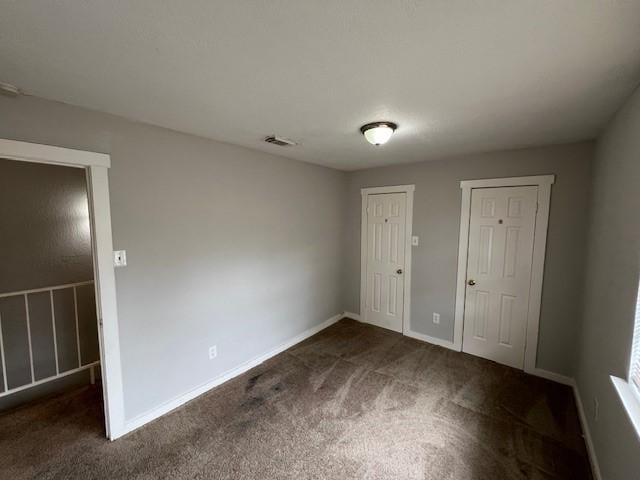 unfurnished room with dark carpet