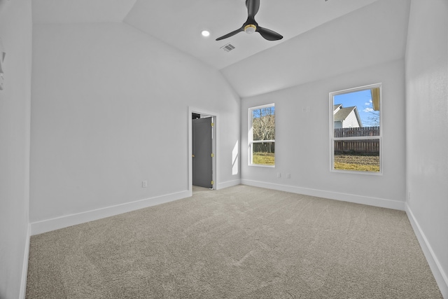 carpeted spare room featuring ceiling fan and vaulted ceiling