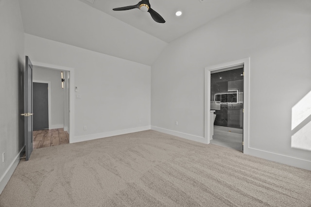 spare room with ceiling fan, light colored carpet, and lofted ceiling