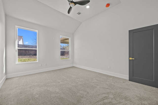 carpeted spare room with lofted ceiling and ceiling fan