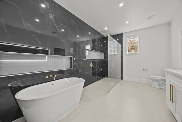 full bathroom featuring vanity, toilet, shower with separate bathtub, and tile walls