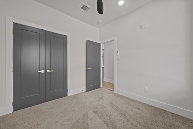 unfurnished bedroom with carpet floors, ceiling fan, and a closet