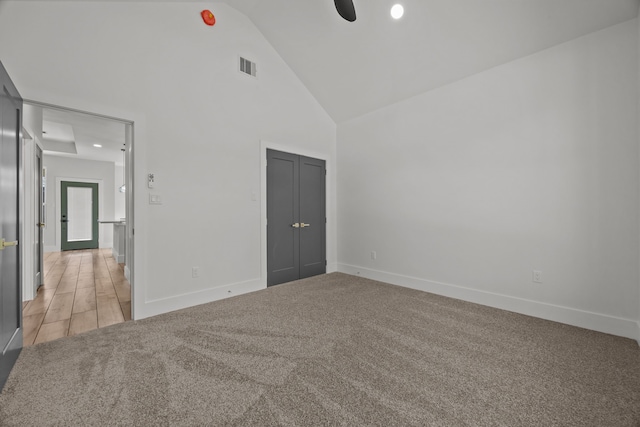 carpeted empty room featuring ceiling fan and high vaulted ceiling