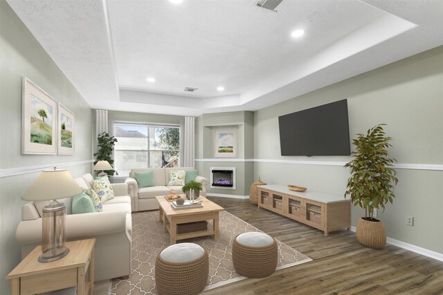 living room featuring a tray ceiling and dark hardwood / wood-style floors