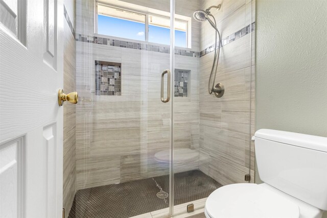 bathroom featuring toilet and walk in shower