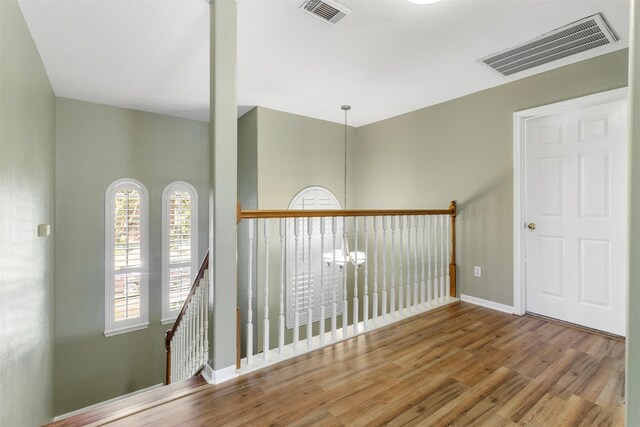 hallway featuring hardwood / wood-style floors and a chandelier