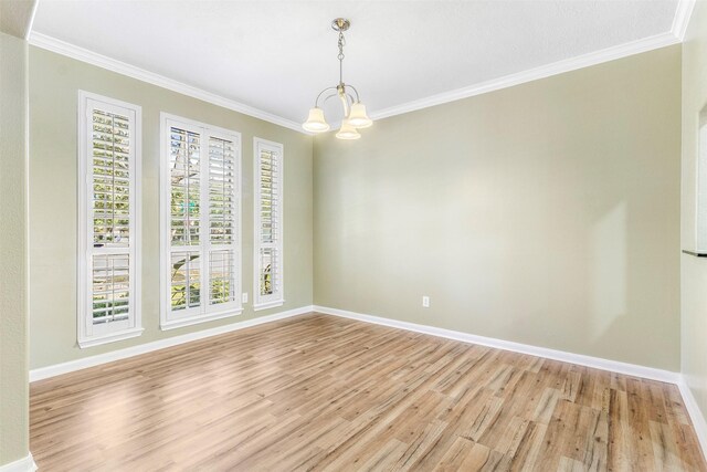 spare room featuring ornamental molding, a chandelier, and light wood-type flooring