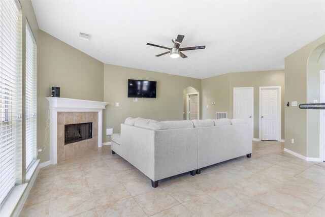 tiled living room featuring ceiling fan and a fireplace