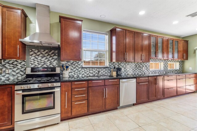 kitchen with appliances with stainless steel finishes, sink, decorative backsplash, and wall chimney exhaust hood