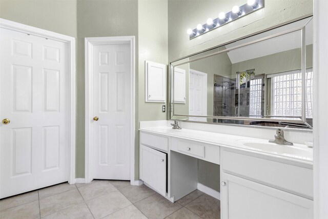 bathroom featuring tile patterned floors, vanity, tiled shower, and vaulted ceiling